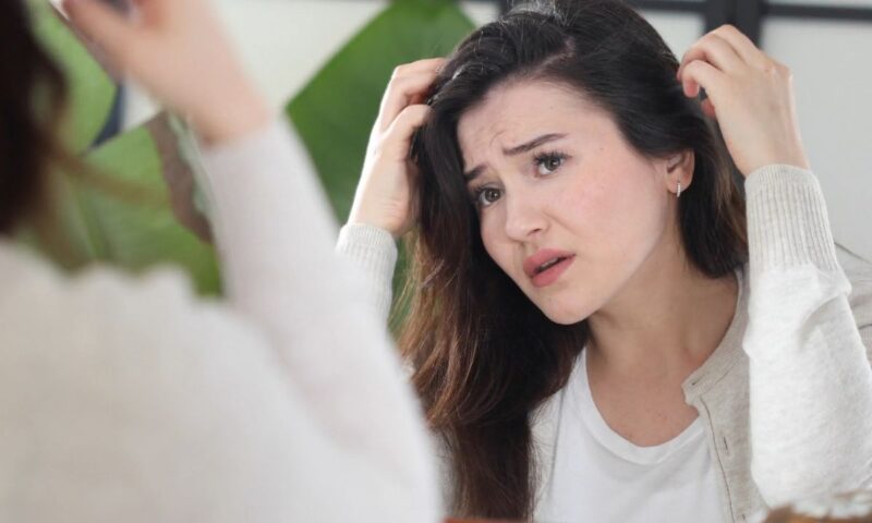 devojka gleda u svoju kosu