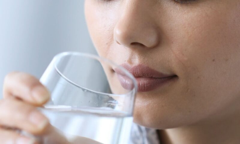 devojka pije vodu iz staklene čaše